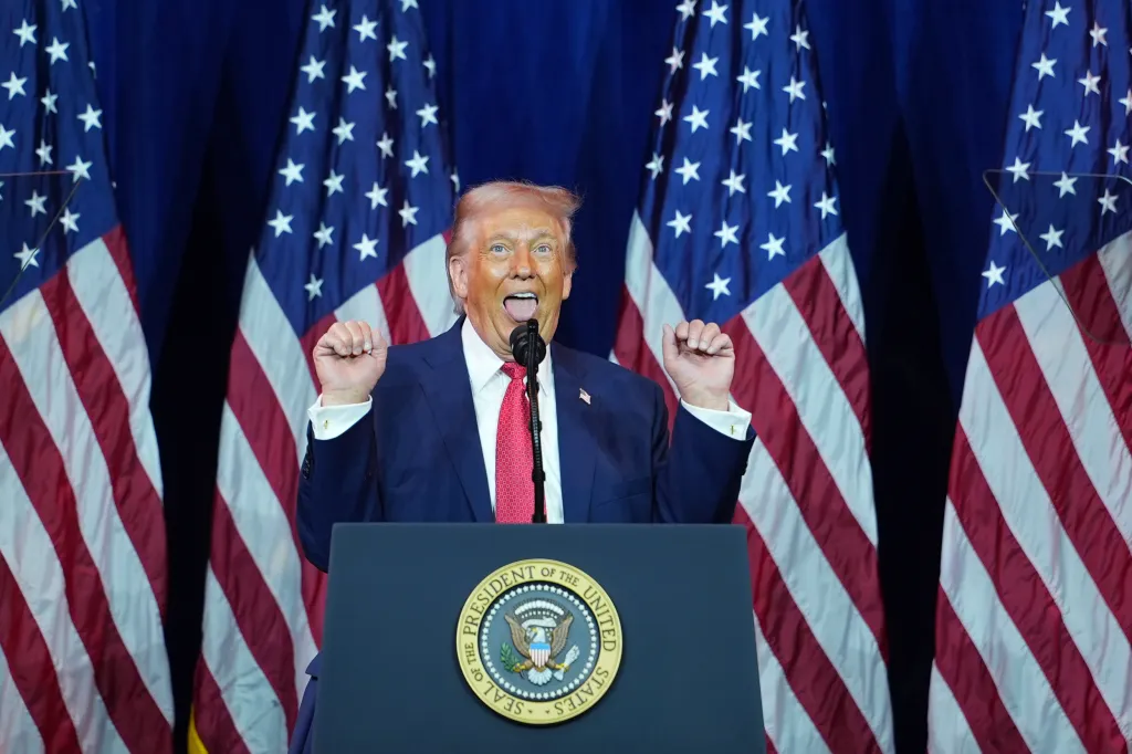 President Donald Trump speaking to House Republican lawmakers with his tongue out and fists raised.