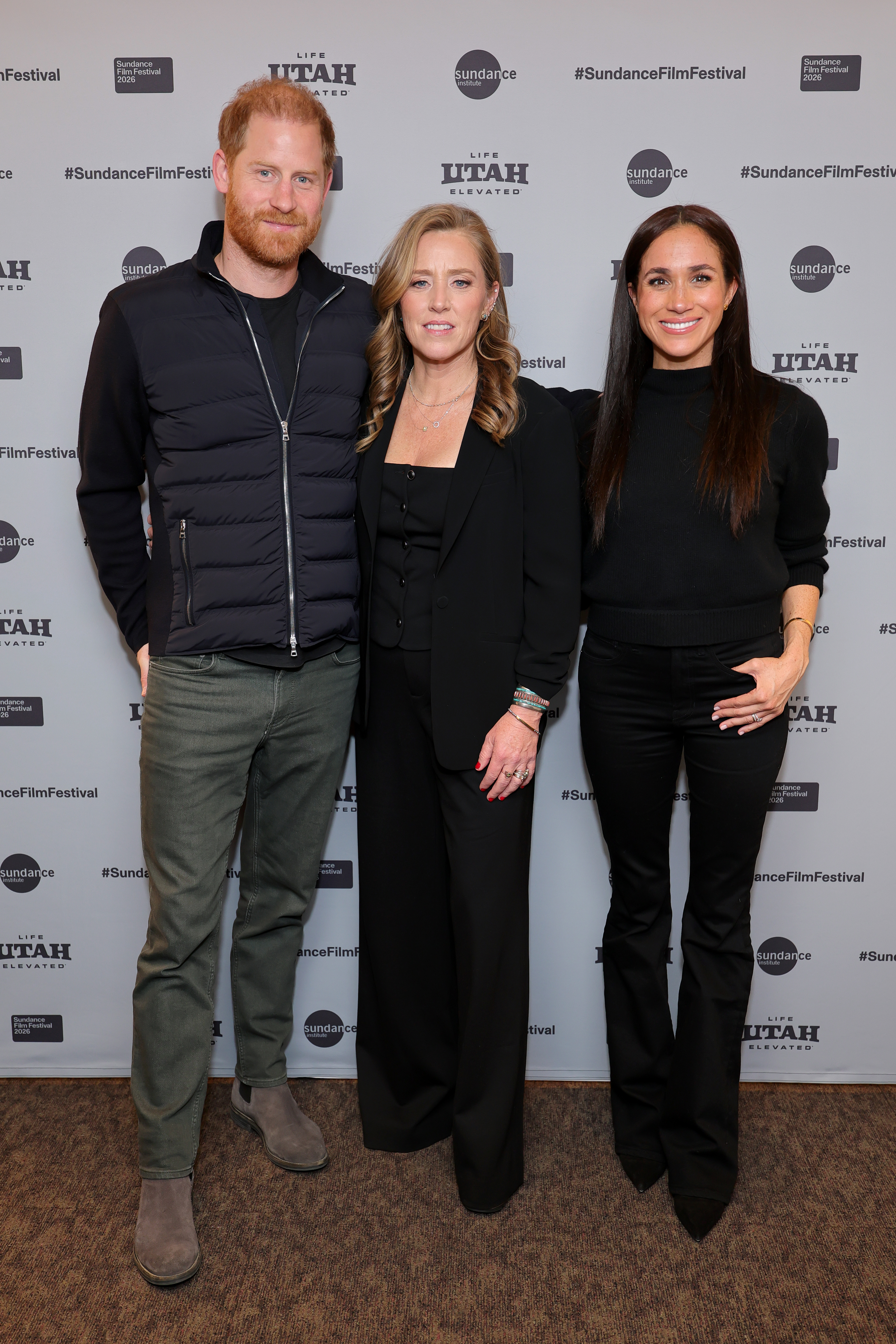 Prince Harry, Amy Redford, and Meghan, Duchess of Sussex, standing together at the Salt Lake City premiere of 