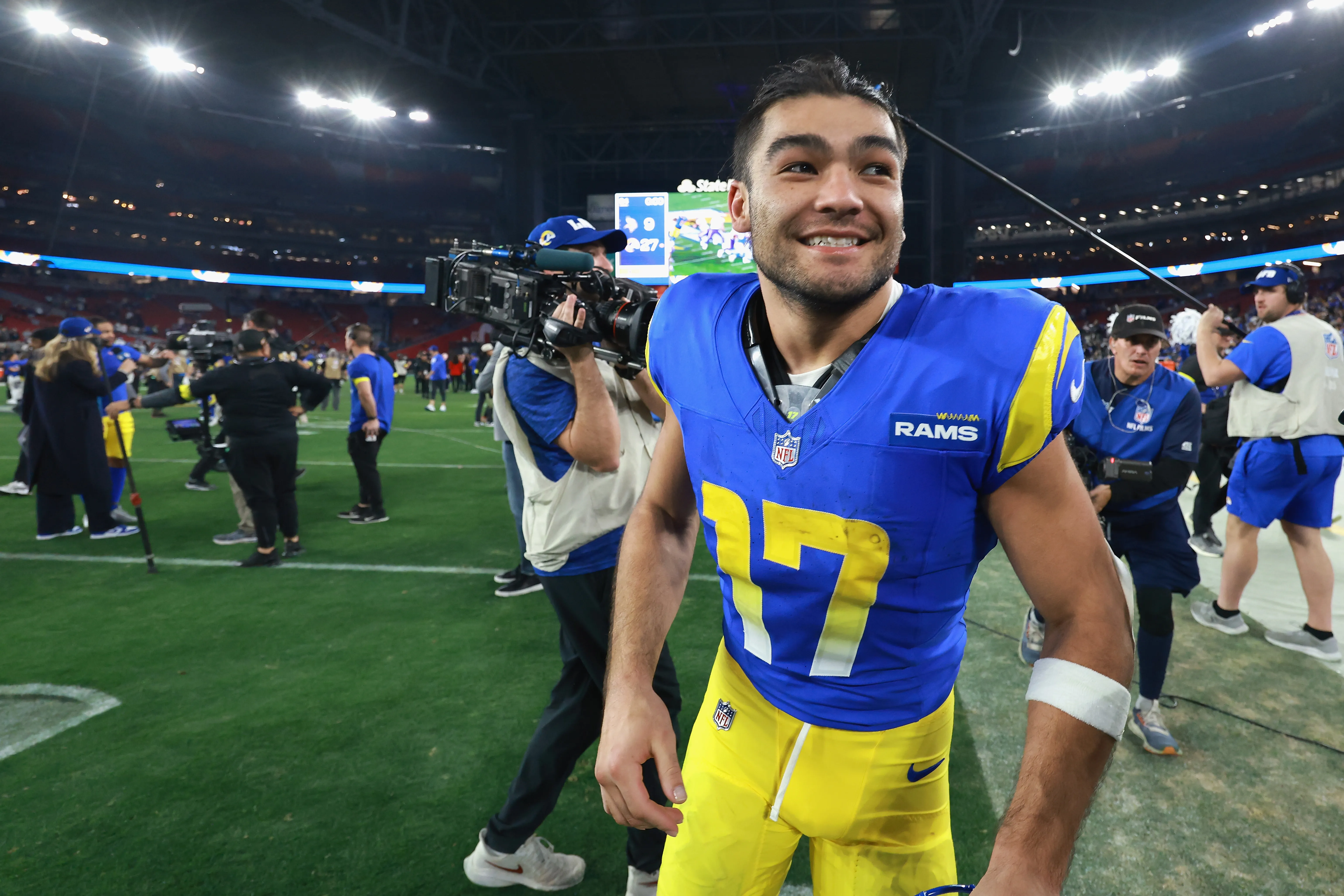 Puka Nacua #17 of the Los Angeles Rams smiles on the field.