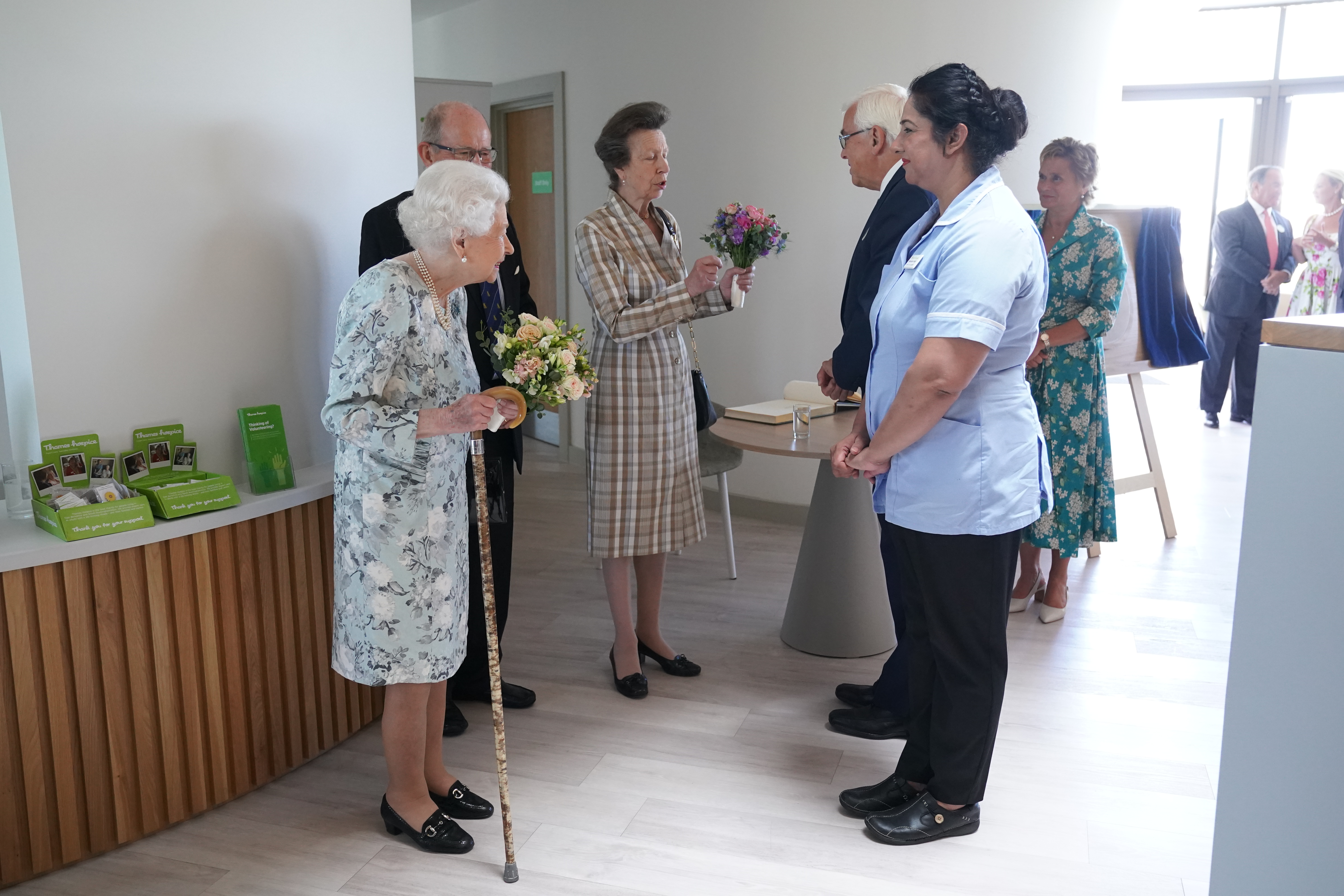 Queen Elizabeth II meets staff as Princess Anne, Princess Royal stands nearby during a visit to officially open the new building at Thames Hospice in 2022.