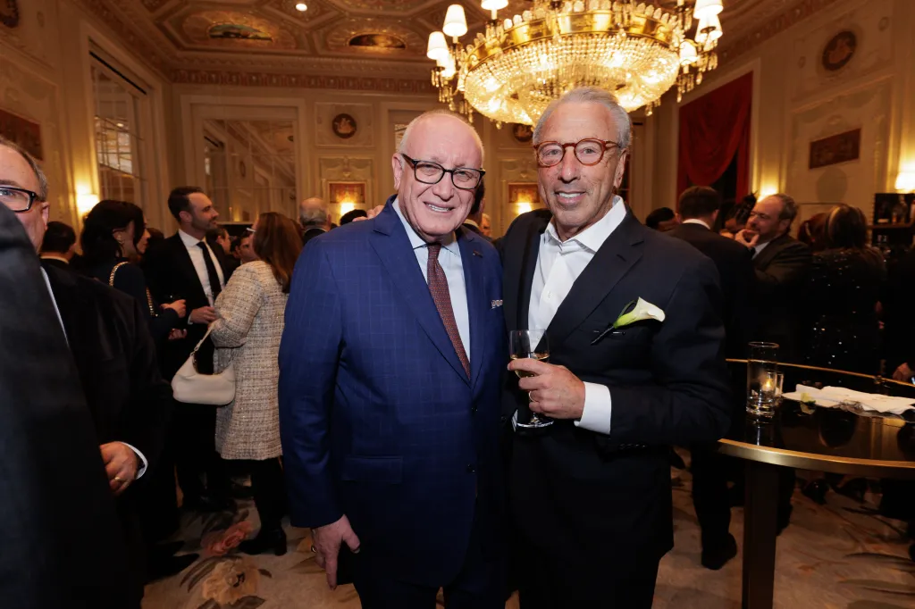 Two men in suits smiling at the 130th Annual REBNY event.