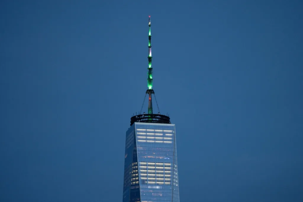 The spire of the One World Trade Center in New York City is lit in green in 