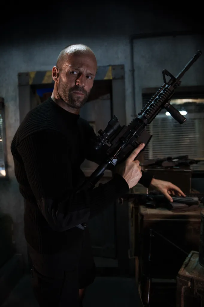 Jason Statham holding a rifle in 