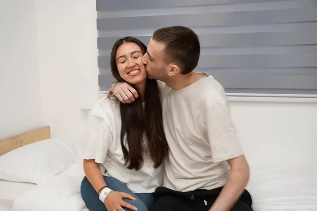 Returned hostage Avinatan Or reunites with girlfriend Noa Argamani, kissing her cheek.