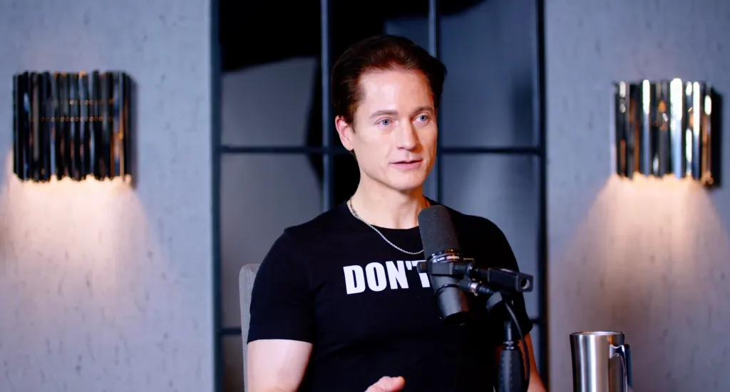Bryan Johnson, 46, in a black shirt with a microphone in front of him.