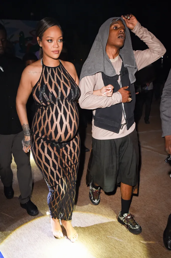 Rihanna and A$AP Rocky walking together at an evening event.