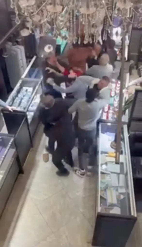 Multiple men brawling in a jewelry store.