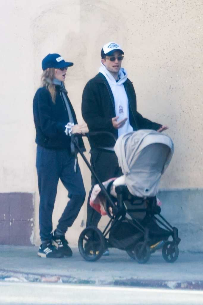 Robert Pattinson and Suki Waterhouse pushing a baby stroller.