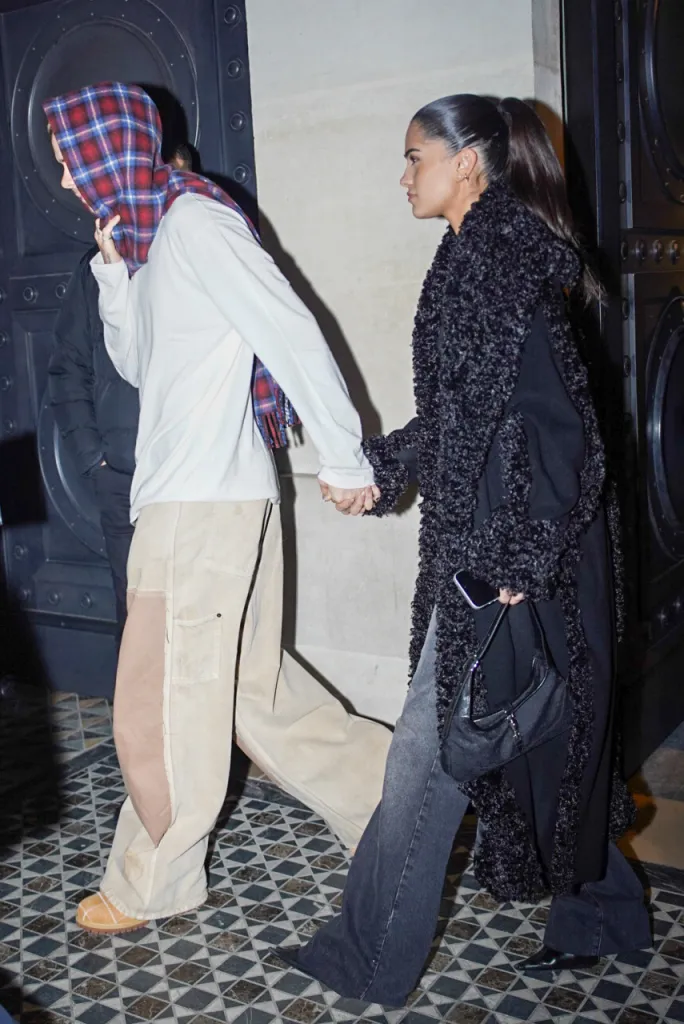 Romeo Beckham and Kim Turnbull holding hands while leaving Hotel Costes in Paris.