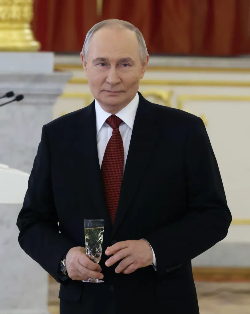 Russian President Vladimir Putin holding a glass of champagne.