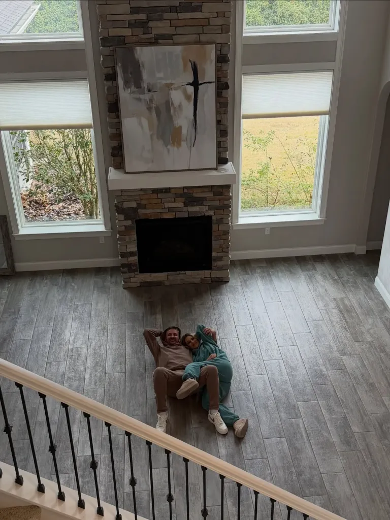 Ryan Lochte and his girlfriend laying on the floor of a new home.