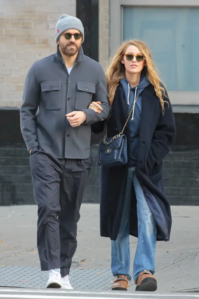 Ryan Reynolds and Blake Lively in casual street clothes, with Lively holding Reynolds' arm.