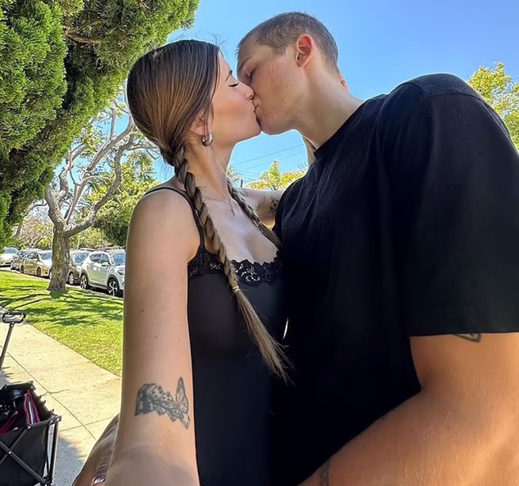 Sami Sheen and Aidden David kissing outdoors.