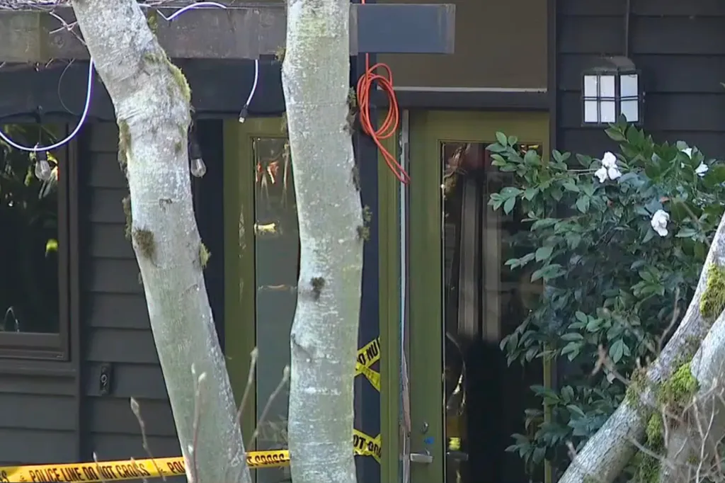 Police line tape stretched across the entrance of a house.