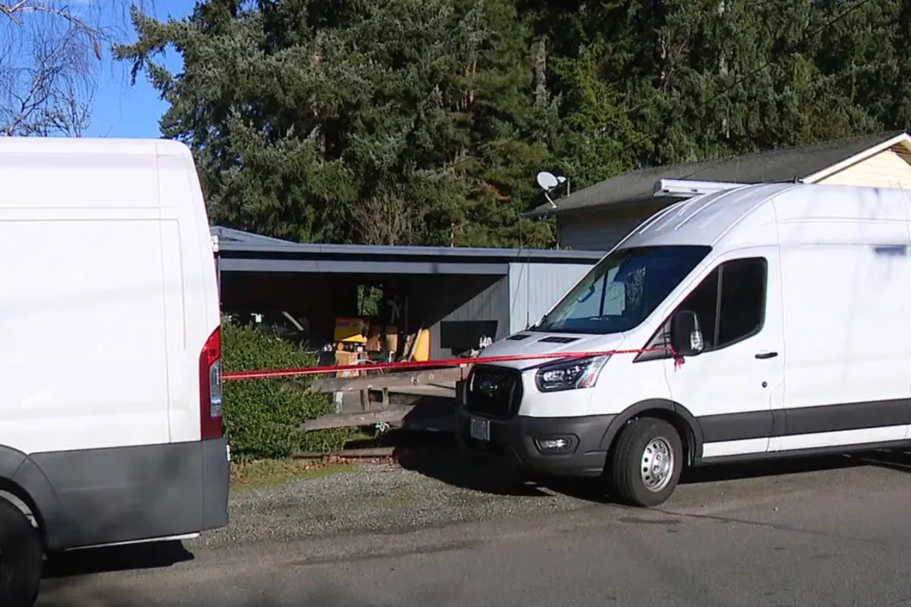 Two white vans with red tape across the front of the right van.