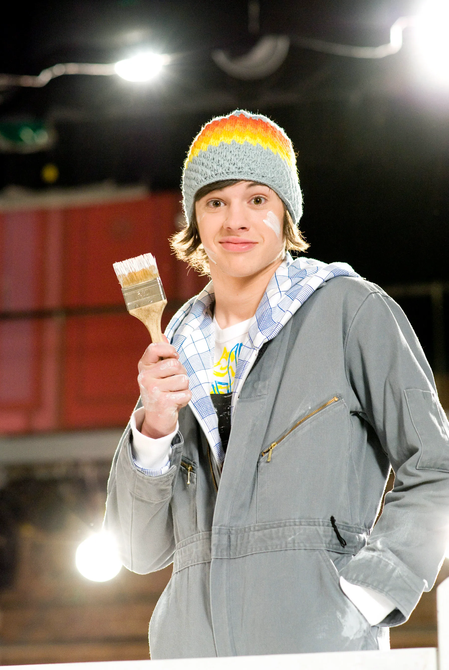 Matt Prokop as Jimmie Zara in High School Musical 3: Senior Year, wearing a beanie, holding a paintbrush, and covered in paint.