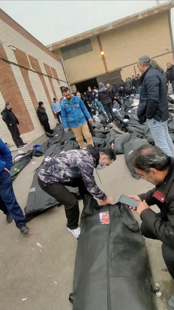 People stand among numerous body bags on the ground outside the Kahrizak Forensic Medical Centre in Tehran.