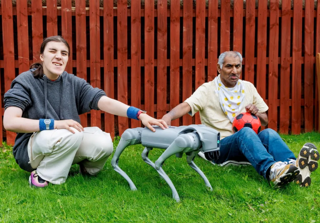 Service users Jessica Wallace and Zafar Iqbal interact with Snoop the robot dog.