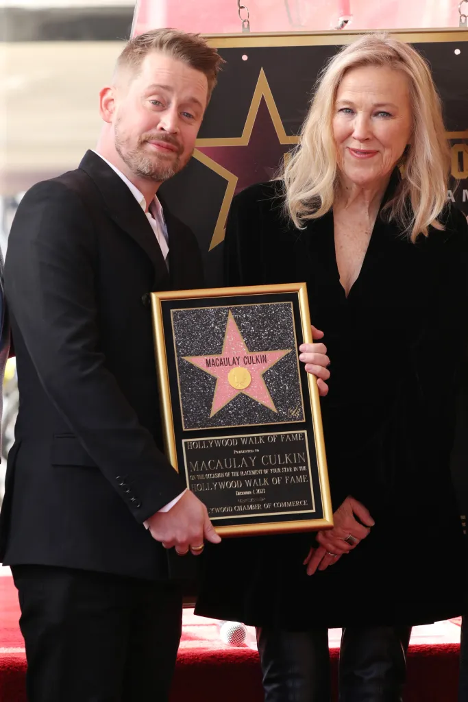Macaulay Culkin and Catherine O'Hara holding a framed plaque for Culkin's Hollywood Walk of Fame star.