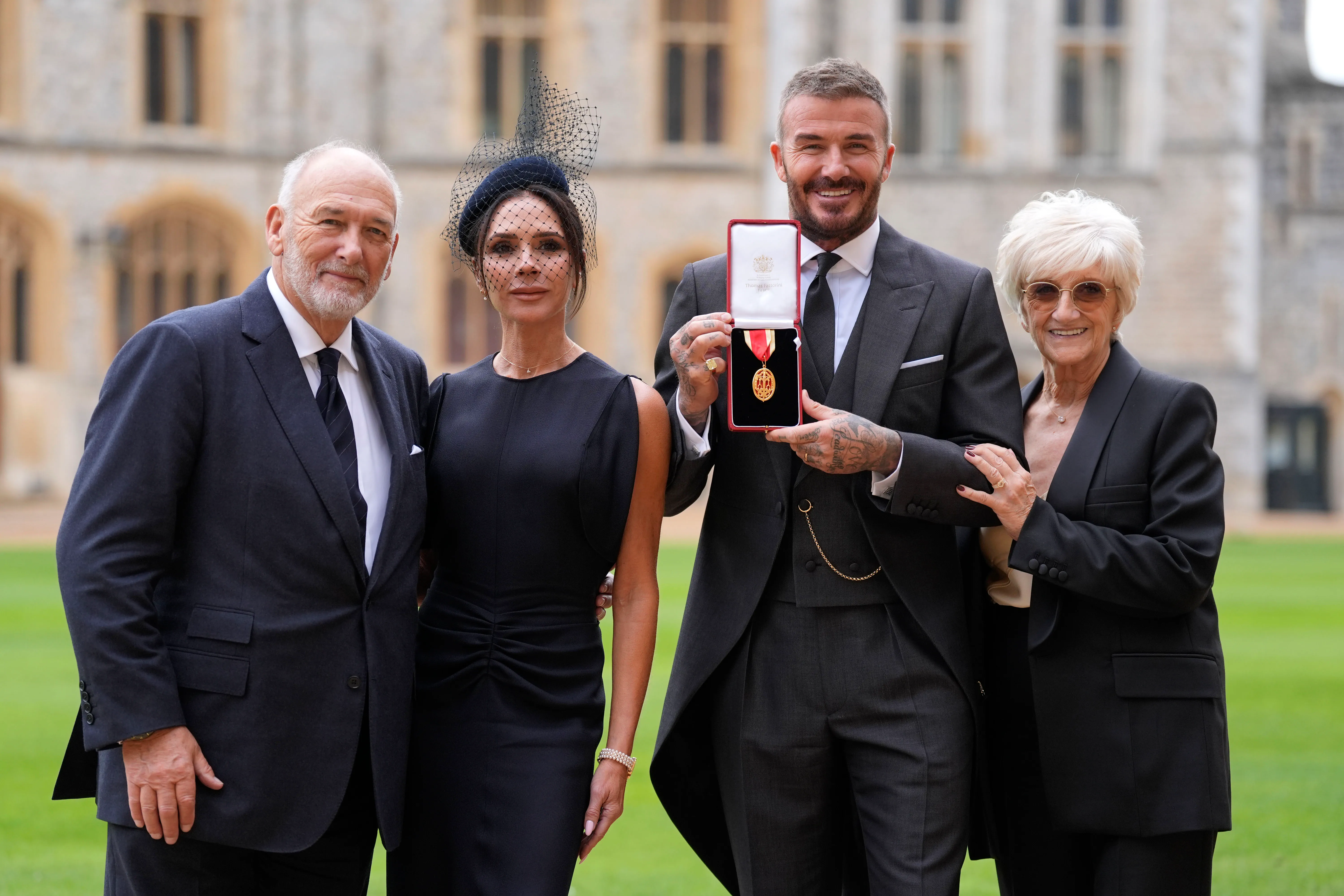 Sir David Beckham, his wife Victoria, and his parents Ted and Sandra Beckham pose with his Knight Bachelor medal at Windsor Castle.