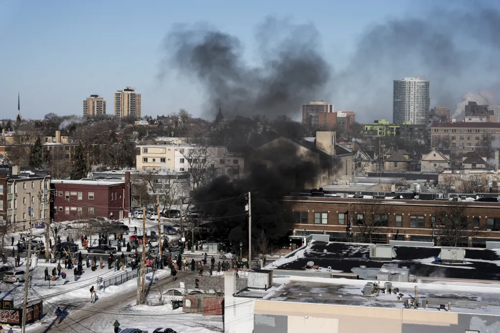 Thick smoke rises from dumpsters during clashes between federal agents and community members in Minneapolis.