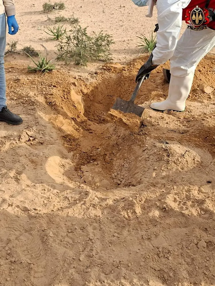 Security personnel and volunteers excavating a mass grave near Ajdabiya, Libya.