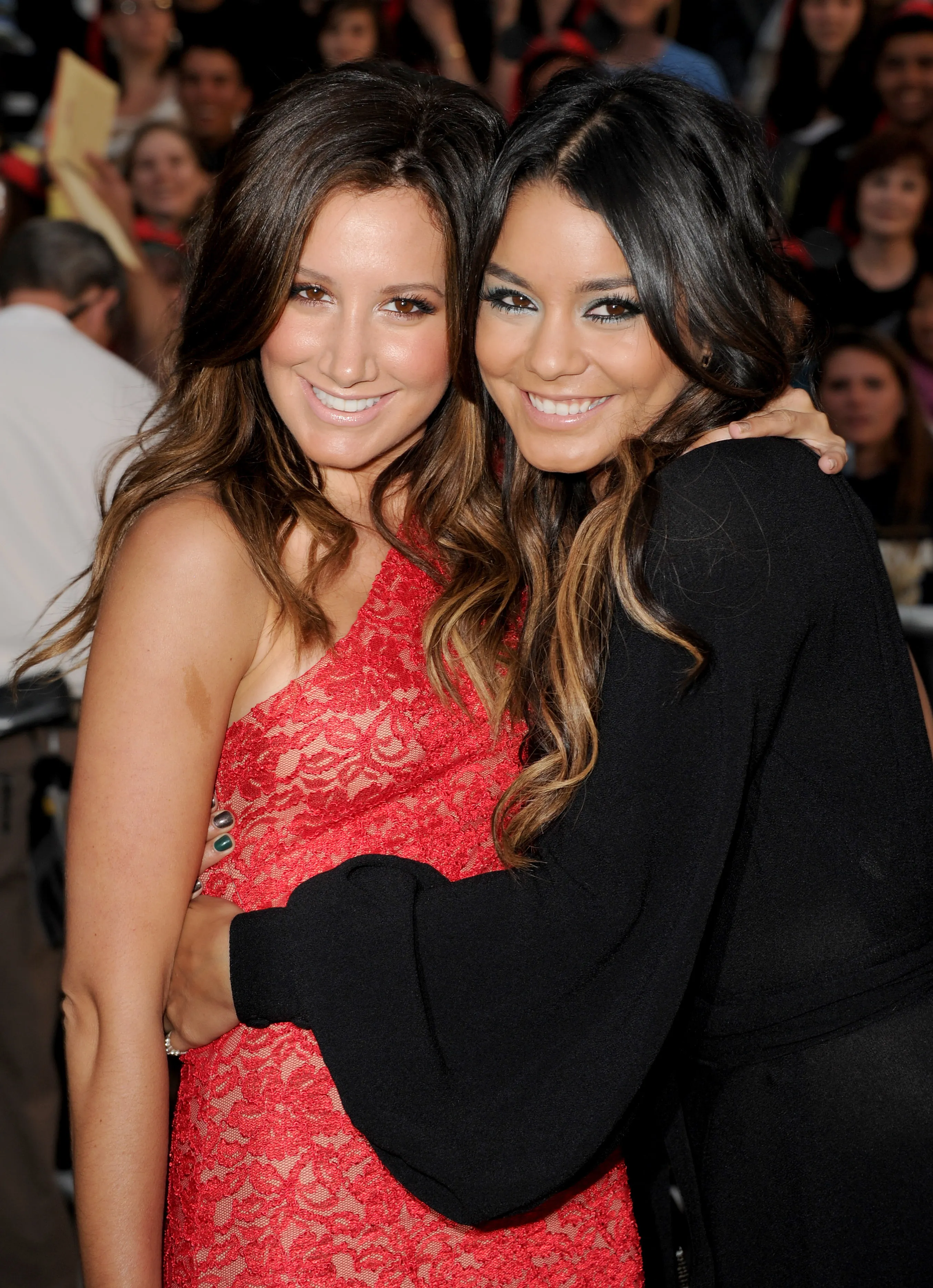 Actresses Ashley Tisdale (L) and Vanessa Hudgens embrace at the premiere of