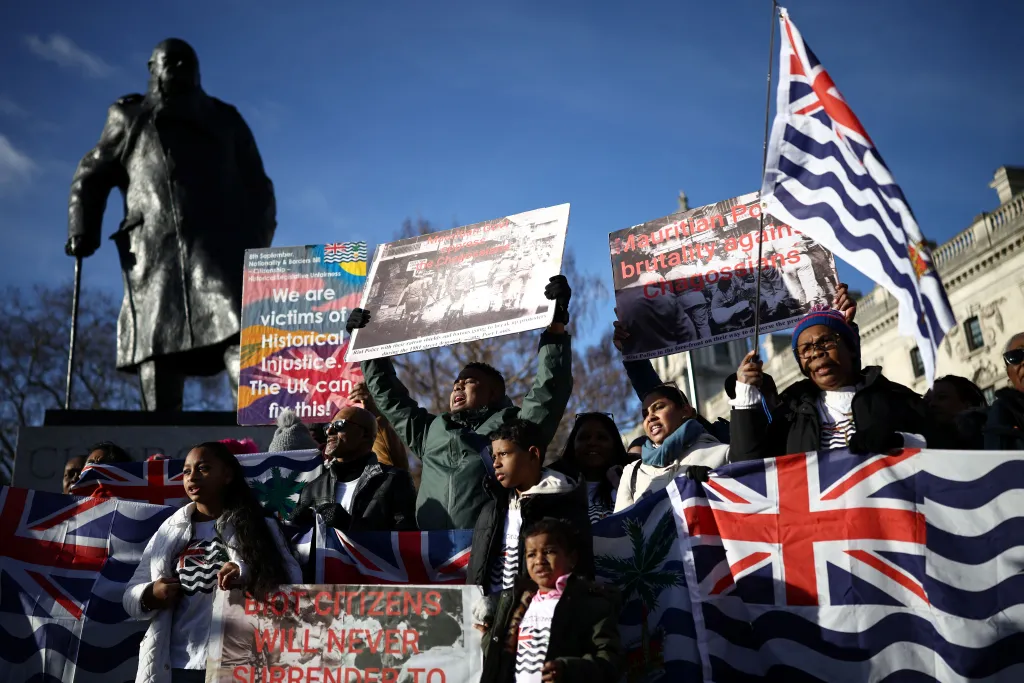 Supporters and members of the British Indian Ocean territory Chagos Archipelago hold placards and the territory's flag outside the Houses of Parliament in London on January 7, 2026