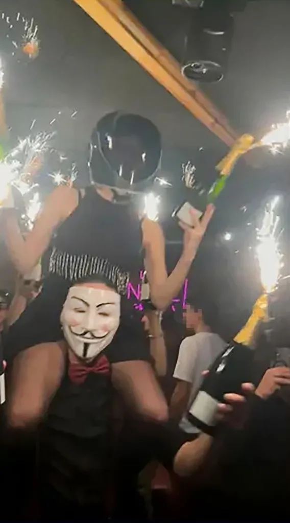 Panine is seen wearing a helmet while holding the bottled with the pyrotechnic candles before the fire broke out.