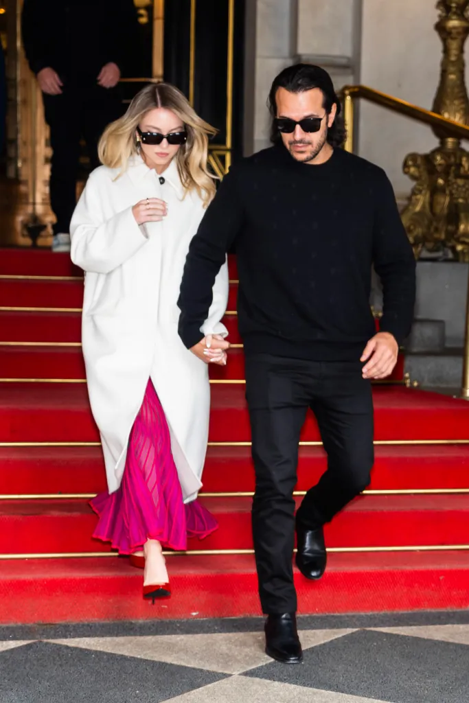 Sydney Sweeney and Jonathan Davino descending red stairs.