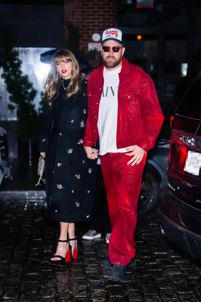 Taylor Swift and Travis Kelce holding hands while leaving a restaurant.