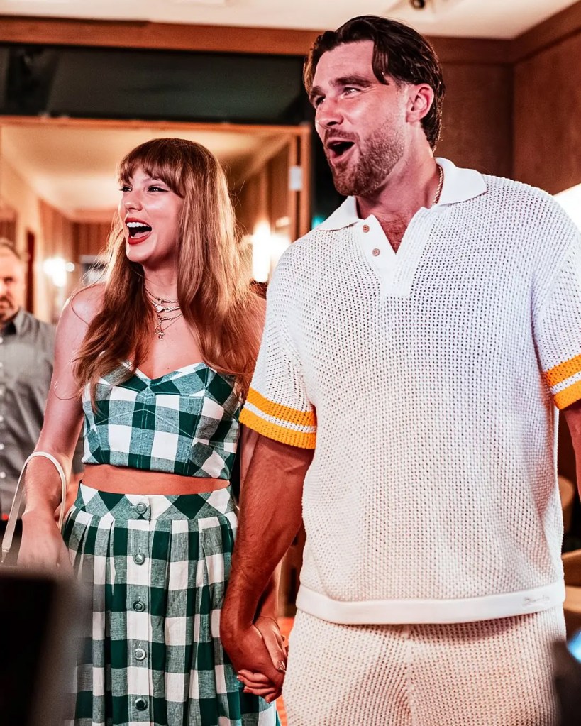 Taylor Swift and Travis Kelce holding hands and smiling.