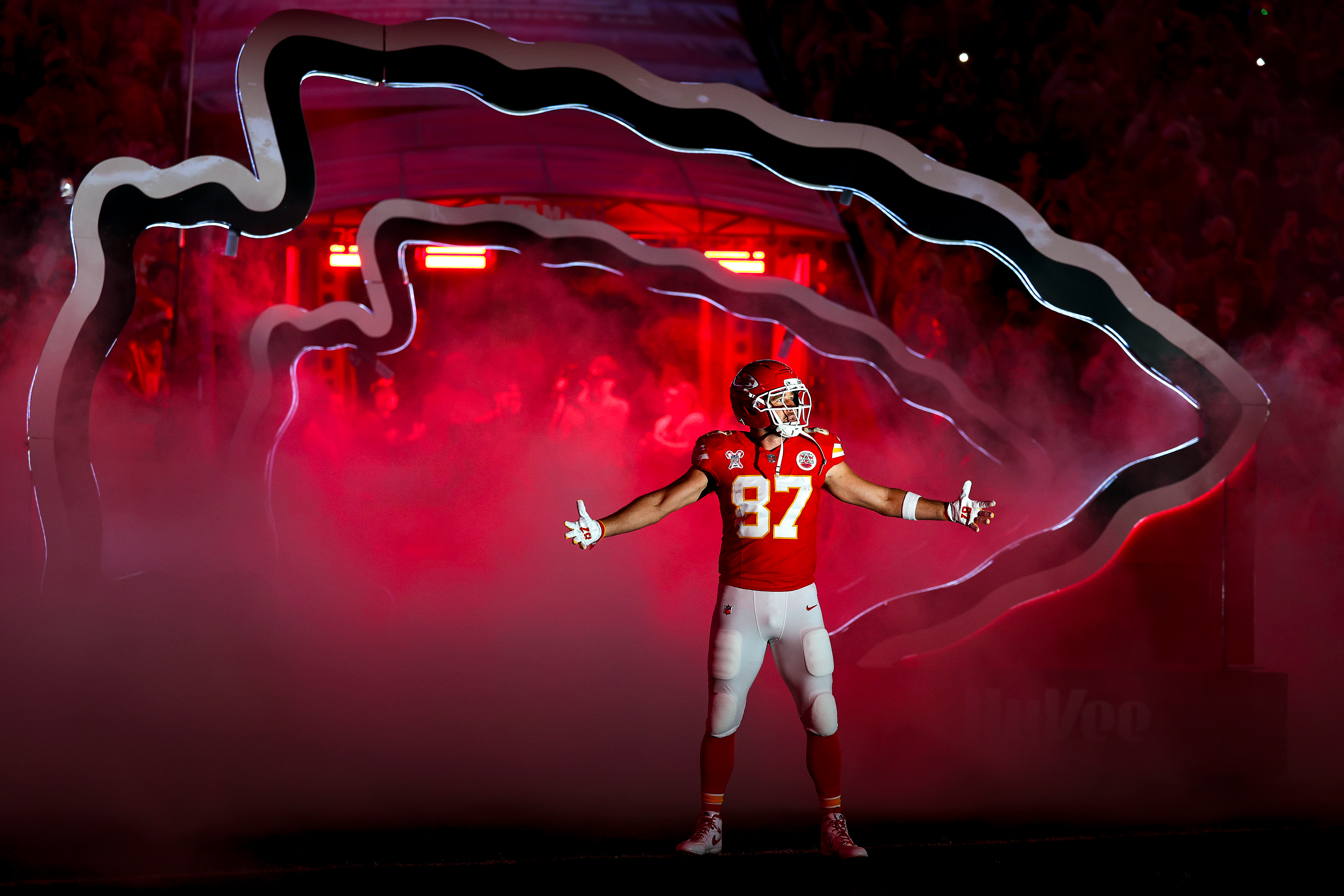 Travis Kelce of the Kansas City Chiefs in his uniform being introduced through a tunnel.
