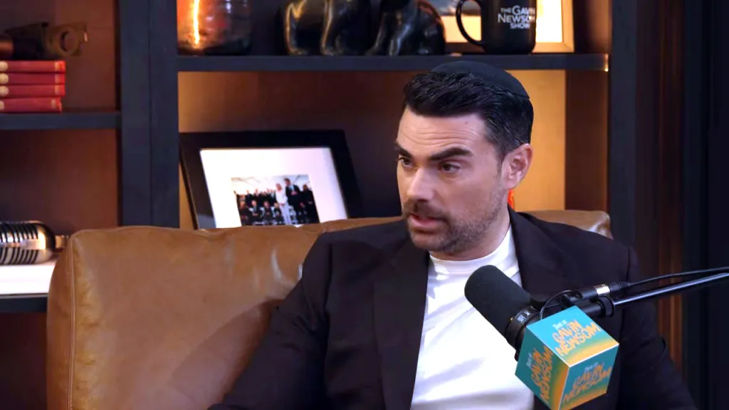 Ben Shapiro in a kippah and black suit jacket, being interviewed on 