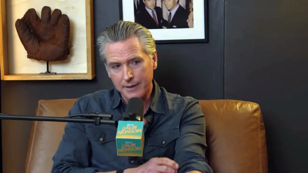 Gavin Newsom speaking into a microphone with 