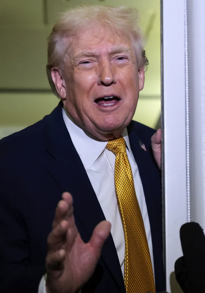 U.S. President Donald Trump speaks to reporters aboard Air Force One.