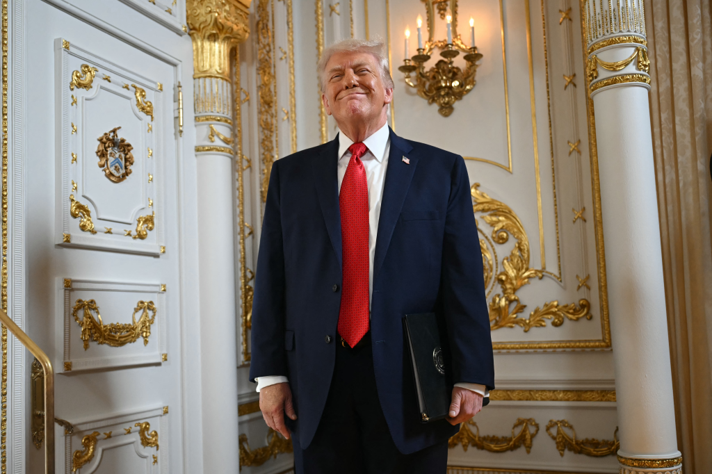 US President Donald Trump smiles in a ballroom.