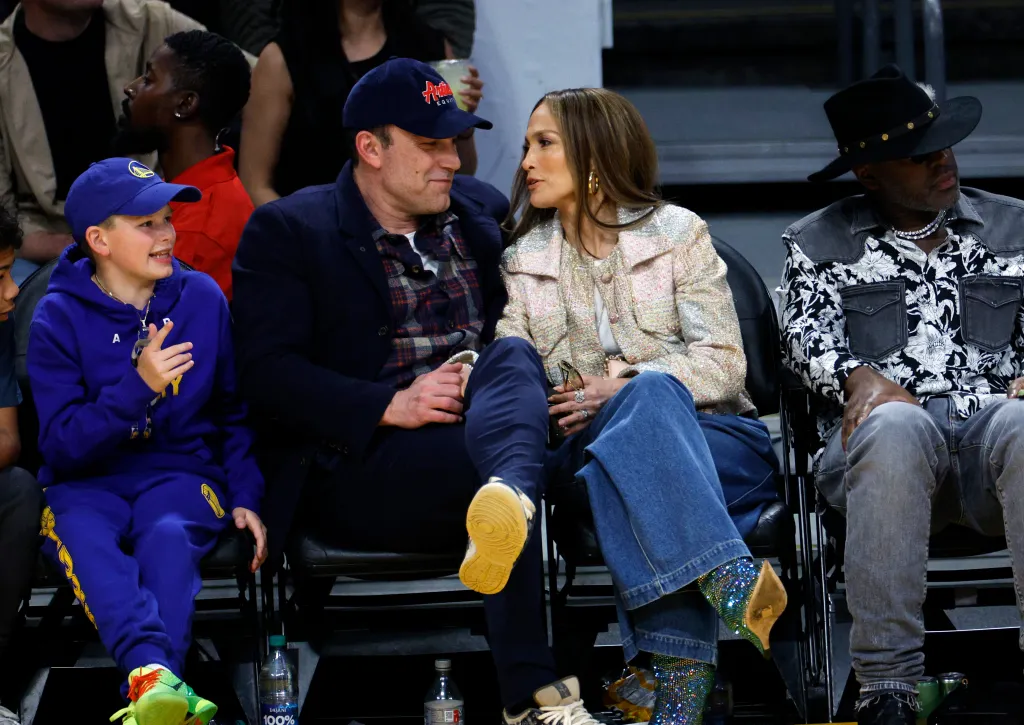 Jennifer Lopez and Ben Affleck with his son Samuel Garner Affleck watching a basketball game.