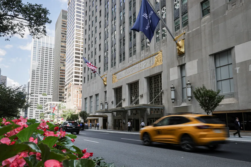 The Waldorf Astoria Hotel in midtown Manhattan, with a taxi driving by.