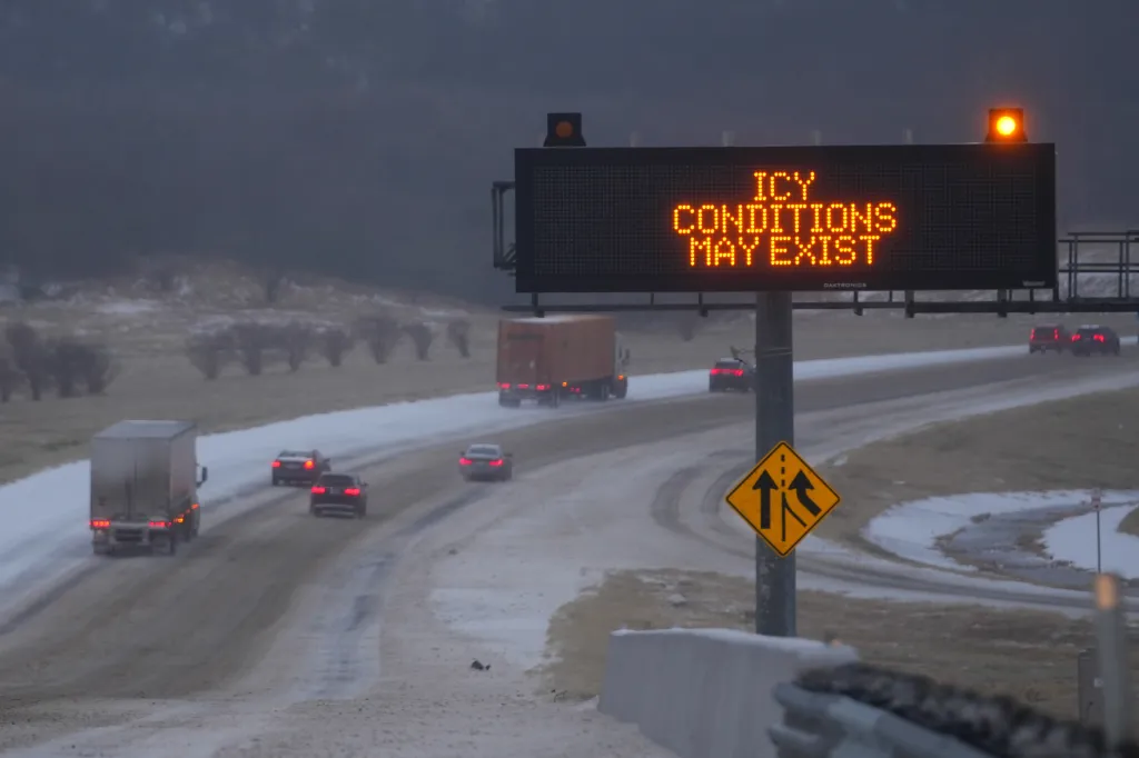 Motorists drive on Interstate-20 under a sign warning of icy conditions in Dallas, Texas, on Jan. 24, 2026.