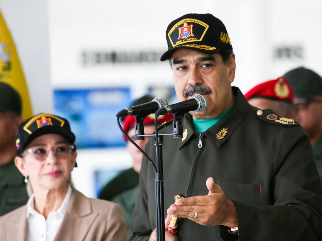 Nicolas Maduro speaking at a military event with Cilia Flores beside him.