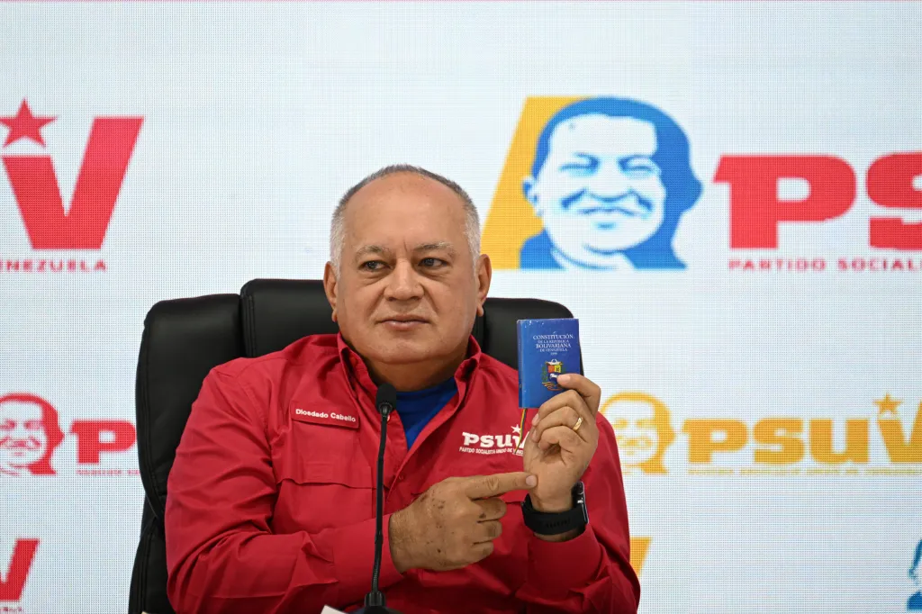 Diosdado Cabello holding a copy of the Venezuelan constitution during a PSUV press conference.