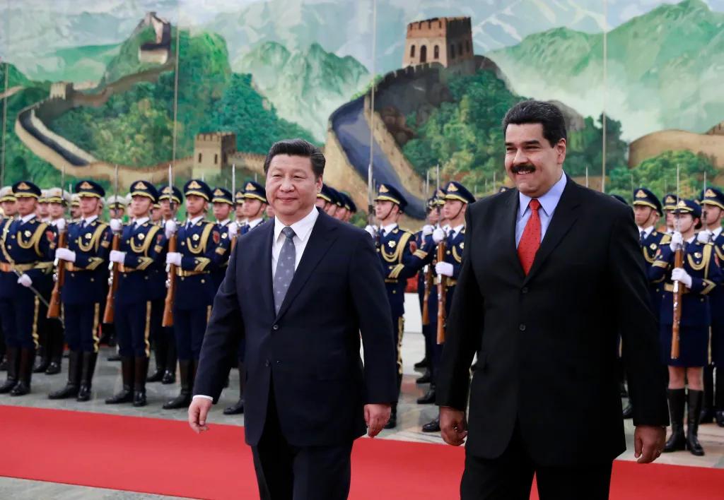 Chinese President Xi Jinping and Venezuelan President Nicolas Maduro walk past an honor guard in the Great Hall of the People.