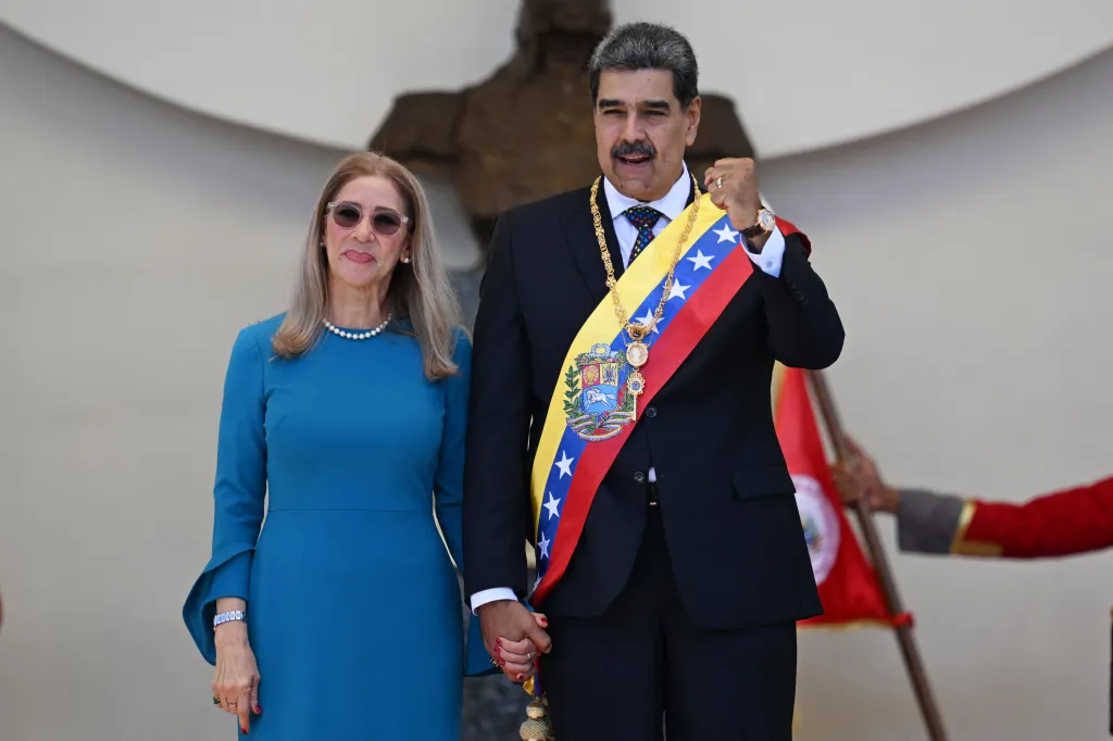 Venezuelan President Nicolas Maduro and his wife Cilia Flores waving at supporters.