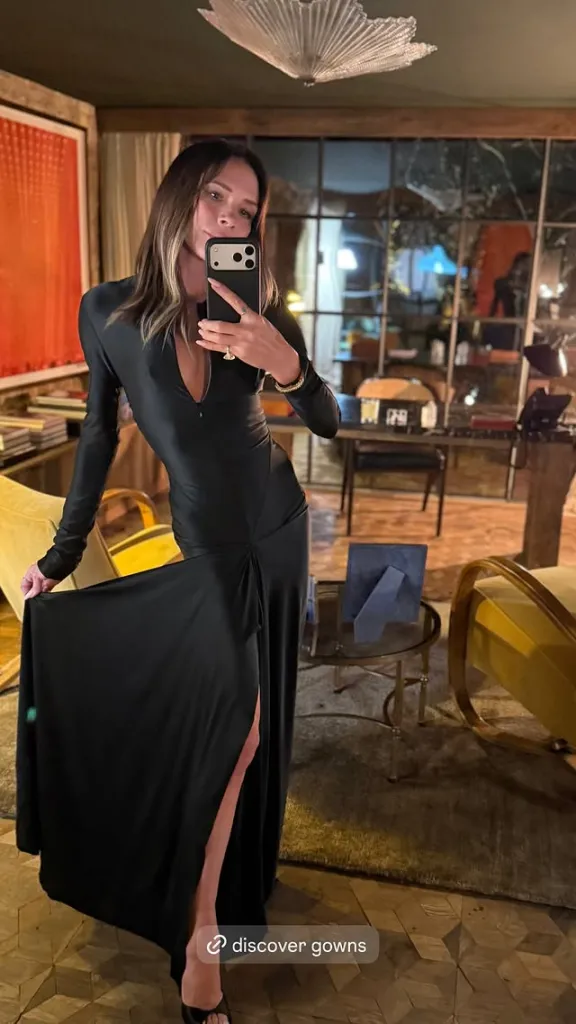 Victoria Beckham taking a mirror selfie in a black gown.