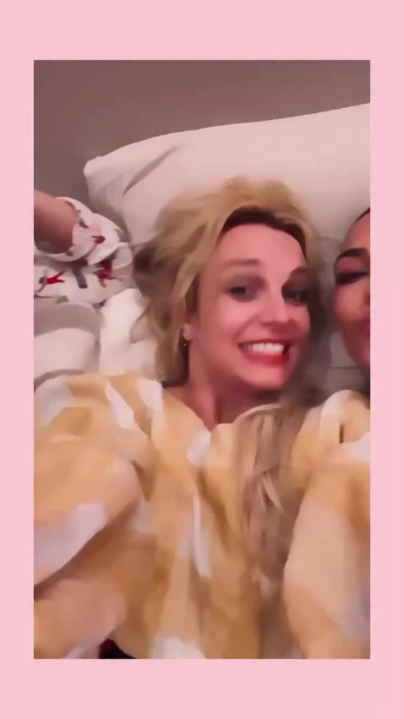 Britney Spears with a wide smile and another Kim Kardashian's partial face in the background.