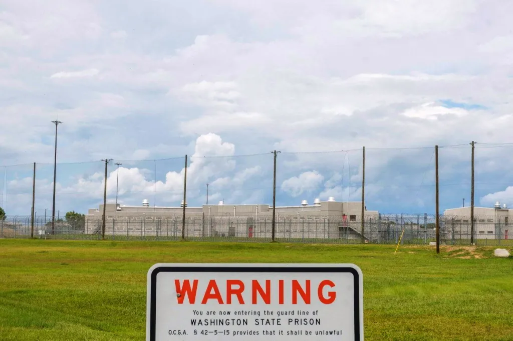 A warning sign for Washington State Prison in Davisboro, Georgia, in front of the prison building.