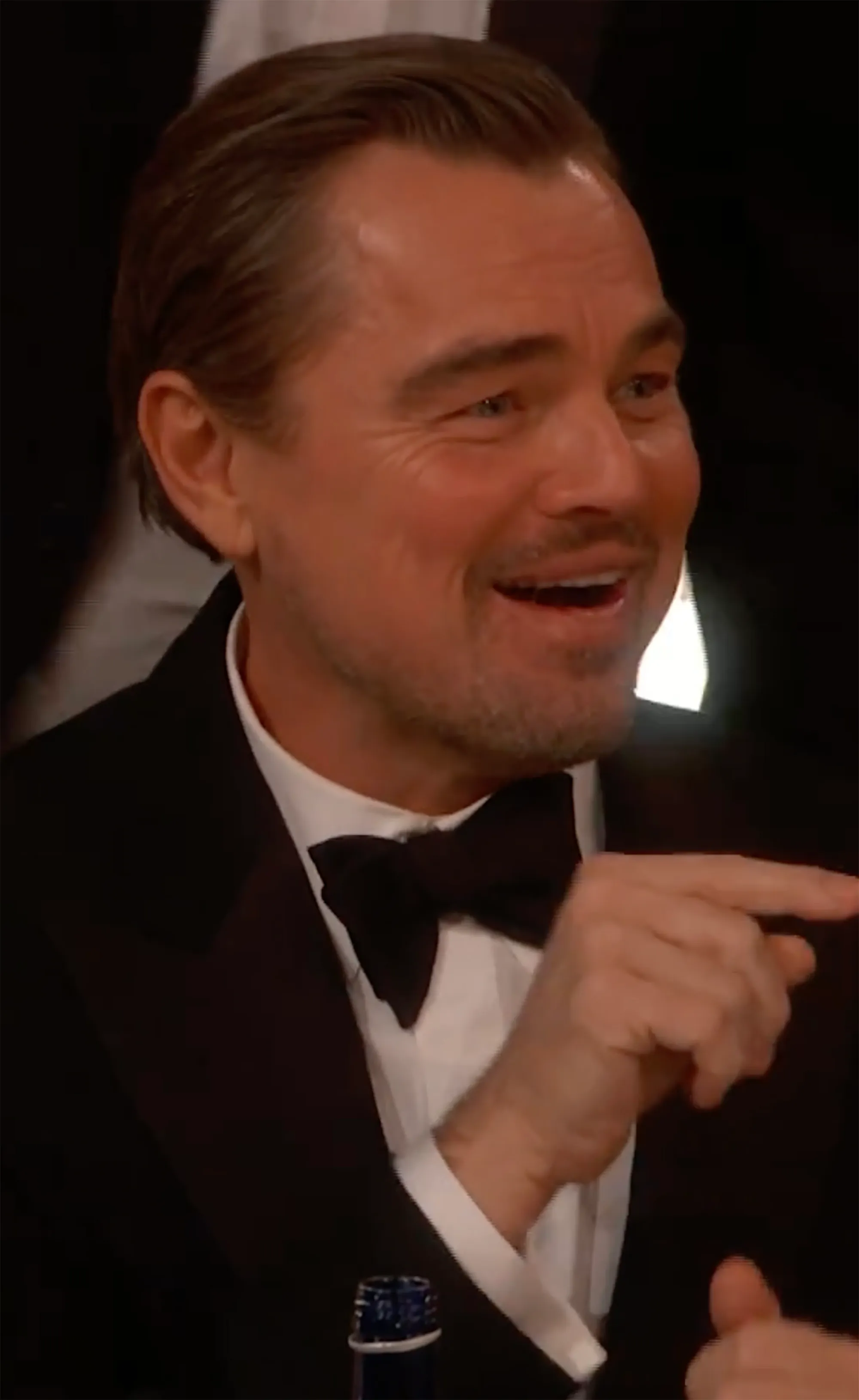 Leonardo DiCaprio smiling and pointing to the side.