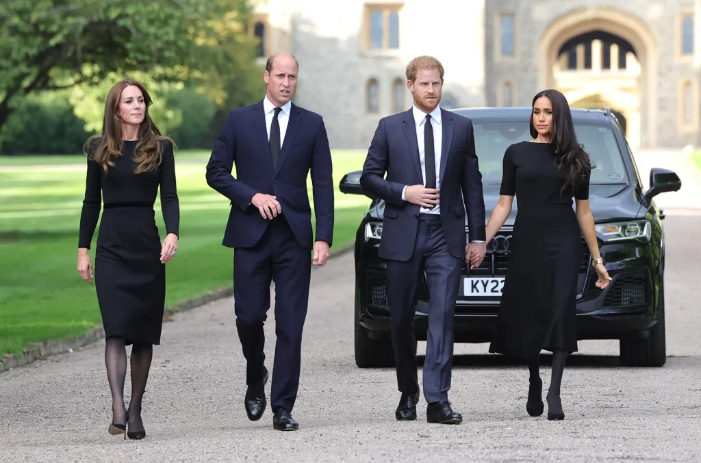 William, Kate, Harry, and Meghan walk together outside Windsor Castle.