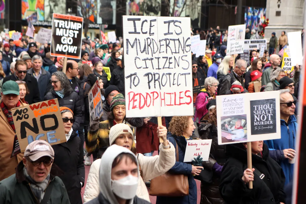 Protesters hold signs during a 